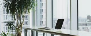 Banner für Blogbeitrag zum Thema  Mehrfachbeschäftigung zeigt Arbeitsplatz mit Laptop