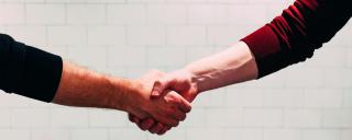 Banner für Blogbeitrag zum Thema Mitarbeitermotivation zeigt einen Händedruck