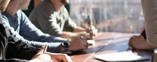 Banner für Blogbeitrag zum Thema Mitarbeiterprämie zeigt Personen um einen Tisch
