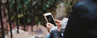 Banner zeigt eine Person, die ein Smartphone hält