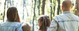 Banner für Blogbeitrag zum Thema Elternkarenz zeigt eine Familie im Wald