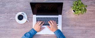 Banner für Blogbeitrag zum Thema Homeoffice zeigt einen Arbeitsplatz mit Laptop und Kaffee