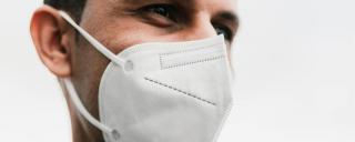 Banner für Blogbeitrag zum Thema COVID-19 Lockerungen zeigt einen Mann mit FFP2-Maske