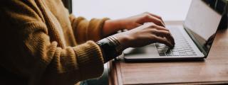 Banner für Blogbeitrag zum Thema Homeoffice zeigt eine Frau, die am Laptop arbeitet